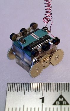 a toy car with gears attached to it next to a ruler