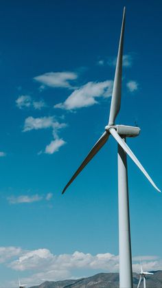 several wind turbines are shown against a blue sky