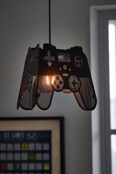 two video game controllers are hanging from a light fixture in a room with a window