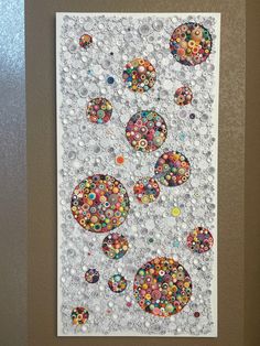 an art piece made out of buttons on a wall