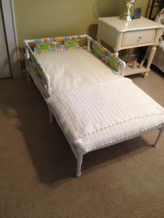 a small child's bed in a bedroom next to a dresser