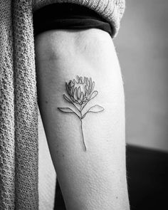 a woman's leg with a small flower tattoo on the left side of her thigh