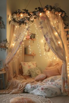 a canopy bed with fairy lights hanging from it's sides and pillows on the floor