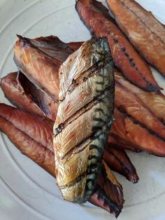 some fish are on a white plate with other food items