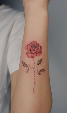 a woman's arm with a rose tattoo on it