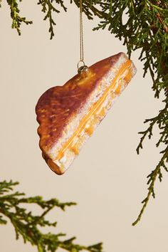 an ornament hanging from a tree branch in the shape of a piece of bread