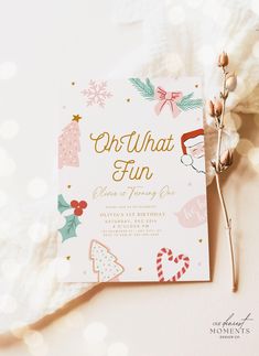 a pink and gold christmas party card on a white surface with lights in the background