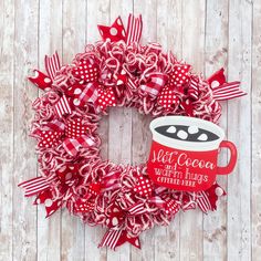 a red and white wreath with a coffee mug on it