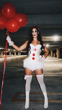 a woman in a costume holding red balloons