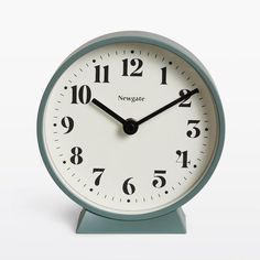 a blue and white clock sitting on top of a table