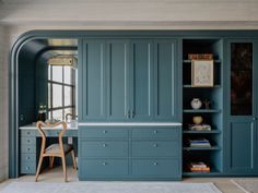 a room with blue cupboards and a white rug on the floor in front of it