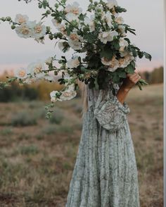 a woman holding a bouquet of flowers on her head in front of an instagram