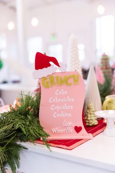 a sign that is sitting on top of a counter in front of some christmas decorations