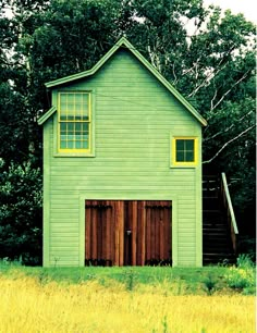 a green building with two doors and windows