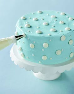 a blue cake with white polka dots on it and a knife sticking out of the top