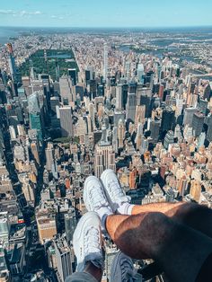 a man standing on top of a tall building with his feet up in the air