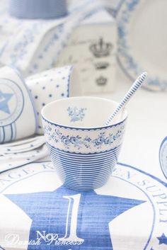 a table topped with blue and white plates and cups