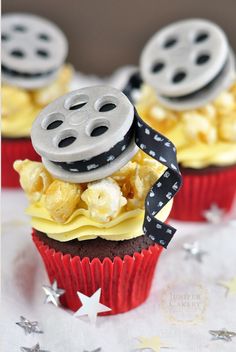 three cupcakes decorated with film reel and popcorn