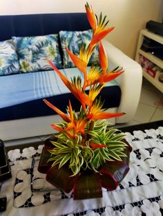 a vase filled with flowers sitting on top of a table next to a blue couch