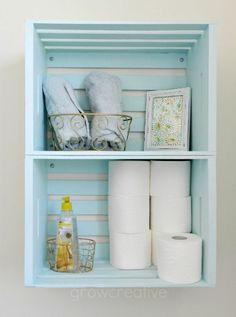 a bathroom shelf filled with toilet paper and other items