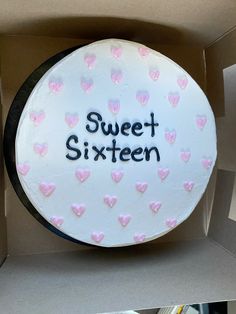 a white cake with pink hearts and the words sweet sixteen written in black on it