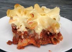 a piece of lasagna on a plate with cheese and meat toppings in it