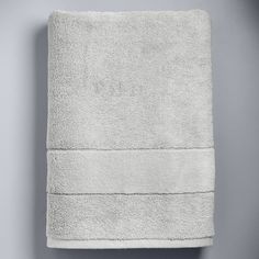 a light blue towel is folded on a gray wall