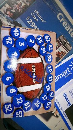 a football themed cake with blue frosting and numbers on the top is surrounded by other items