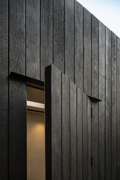 an open door on the side of a wooden building that is made out of wood planks