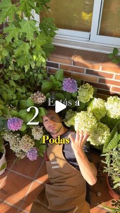 a woman sitting on the ground in front of some flowers and plants with text overlay