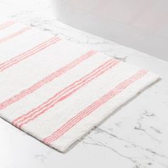 a bathroom rug with pink and white stripes on it