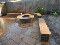 a stone patio with a fire pit in the middle