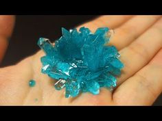 a small cluster of blue crystals in someone's hand