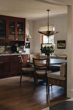 a dinning room table and chairs in front of a window