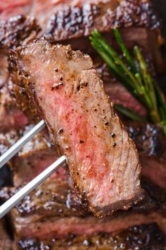 the steak is being grilled on the grill with two tongs in it's mouth