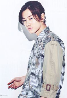 black and white photograph of a woman with short hair wearing a button up shirt, standing in front of a wall