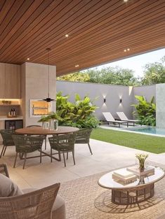 an outdoor living area with tables and chairs next to a swimming pool in the background