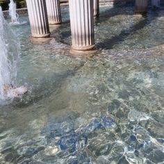 the water is crystal clear and there are columns in the back ground with blue paint on them