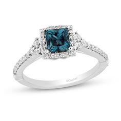 a blue diamond ring with white diamonds on the shoulders and sides, set in 18k white gold