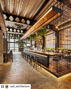 the interior of a modern restaurant with wooden walls and metal railings on the ceiling