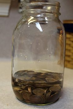 a glass jar filled with coins sitting on top of a counter