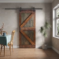 a dining room with a table and chairs next to a barn door that is open