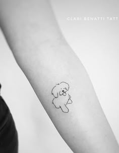 a small dog tattoo on the arm