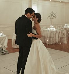 a bride and groom share their first dance at their wedding reception in an elegant ballroom