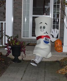 a large inflatable marshmallow sitting on top of a sidewalk next to a house