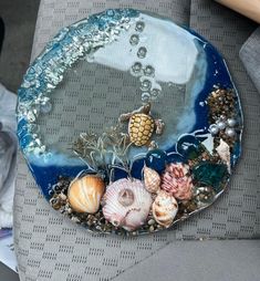 there is a plate with shells and seaweed on the bottom, along with other seashells