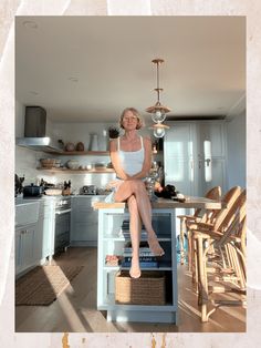 a woman sitting on top of a kitchen counter