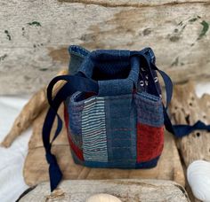 a small blue bag sitting on top of a wooden board next to shells and sea urchins