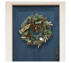 a blue door with a green wreath and bells on the front entrance to a house