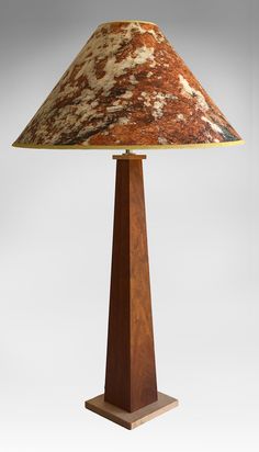 a lamp that is sitting on top of a wooden base with a marbled shade